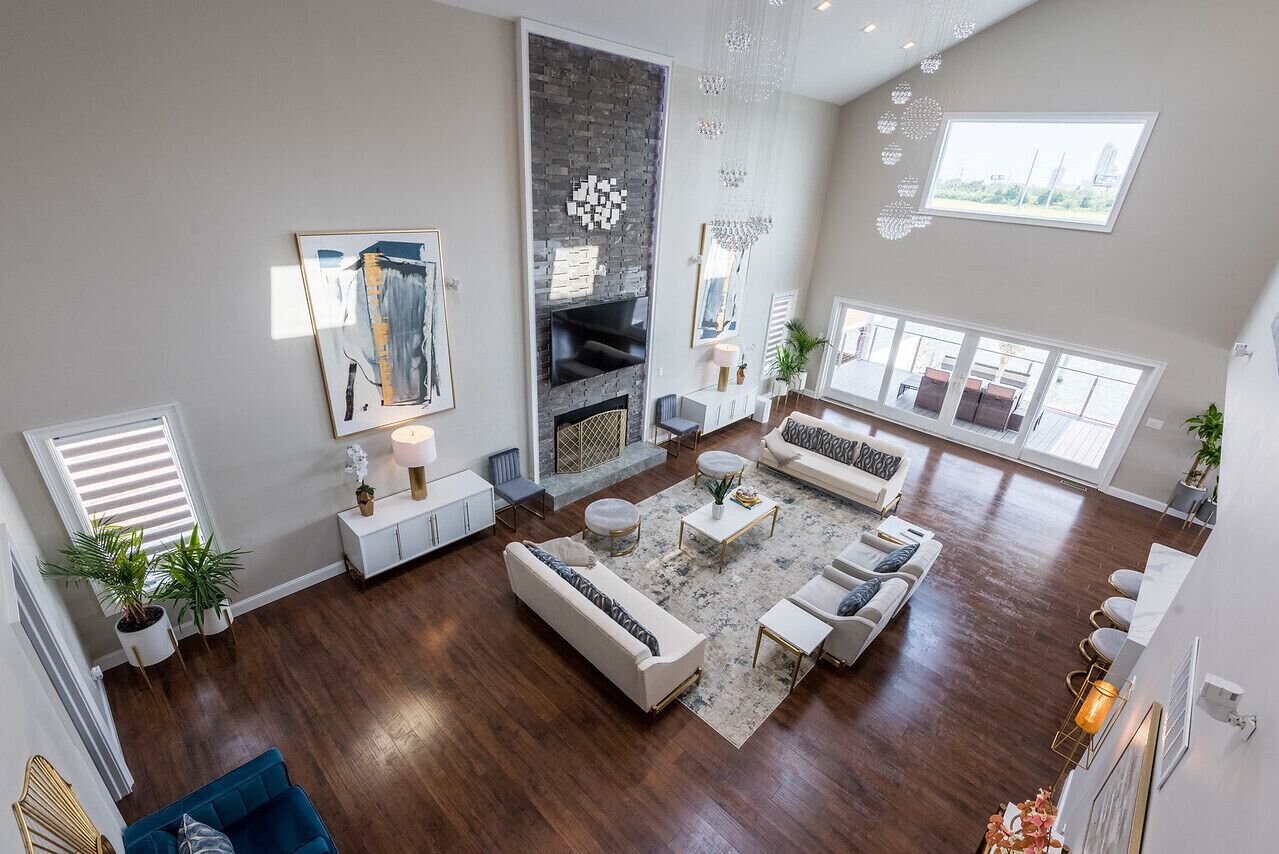 A spacious living room with a fireplace, modern furniture, and large windows offering views of the city.