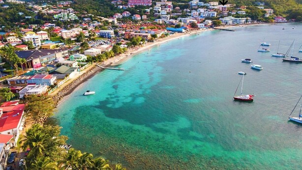 A coastal town with clear turquoise waters, boats, and colorful buildings along the shore. - T2 40 m2 Anse Mitan - Panorama bay of Fort-de-France (Les Trois-Îlets)