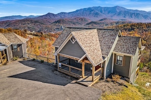 A residential area with houses featuring pitched roofs and a mountainous backdrop.