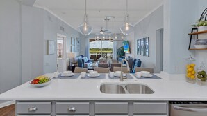 A modern kitchen with a central island, stainless steel appliances, and a dining area with a view of the outdoors. - Top floor condo w/view of lake, pool and fireworks! - Next to conv. center (Orlando)