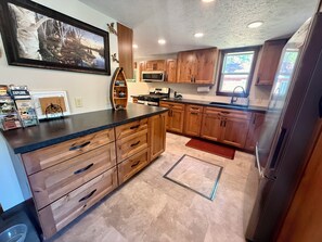 A kitchen with wooden cabinets, a microwave, and a refrigerator.