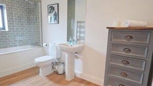 Une salle de bain équipée d’une douche, de toilettes, d’un lavabo et d’un meuble avec des tiroirs.