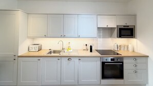 Eine moderne Küche mit weißen Schränken, einem Backofen, einer Mikrowelle und einem Toaster.
