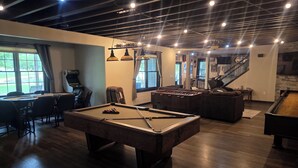 A pool table, foosball table, and a billiards table in a room with a high ceiling and exposed beams. - 6 Bedroom house on 7 acres (Sheboygan Falls)