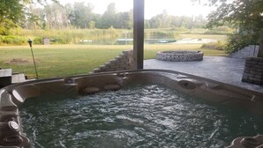 A hot tub with a stone surround and a wooden deck area. - 6 Bedroom house on 7 acres (Sheboygan Falls)