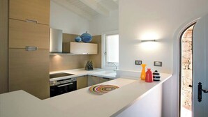 Eine moderne Küche mit Einbauofen, Spüle und Fenster.