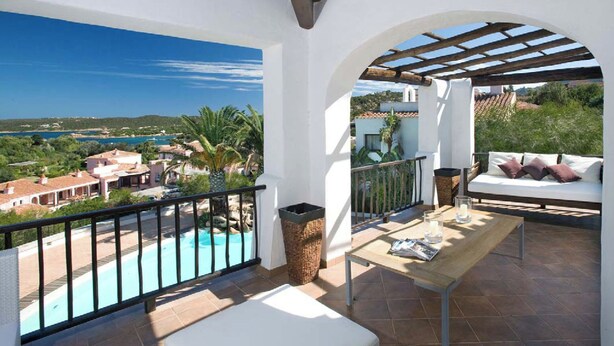 Ein Balkon mit Blick auf einen Pool und die umliegenden Gebäude.