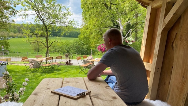 Une table en bois sur laquelle repose un livre, le tout posé sur un tapis blanc et moelleux.