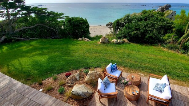 A patio with outdoor furniture overlooking a beach.