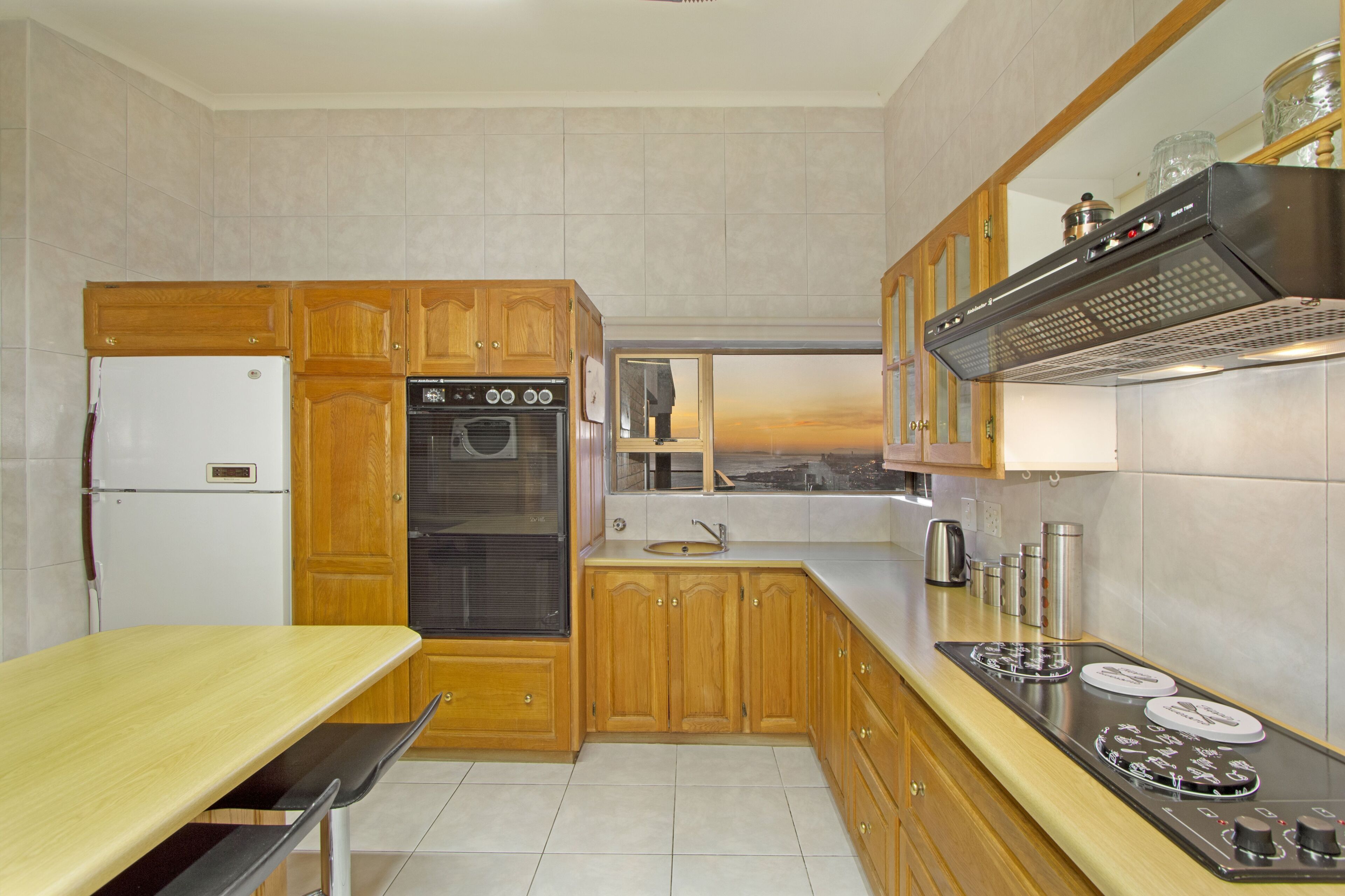 A kitchen with wooden cabinets, a stainless steel stove, and a white refrigerator.