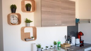 Uma cozinha moderna com prateleiras de madeira, um relógio e diversos eletrodomésticos.