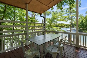 A covered outdoor area with a table and chairs, overlooking a body of water and greenery. - PRIVATE PENINSULA on LAKE NORMAN Pet Friendly! (Denver)