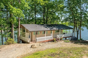 Een chalet met een veranda, een steiger en uitzicht op het meer.
