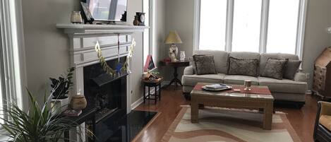 A living room with a fireplace, a television, a sofa, and a coffee table.