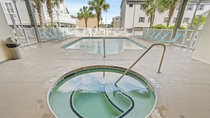 Una piscina con indicador de profundidad de 90 centímetros, rodeada de sillas de descanso y una valla blanca.