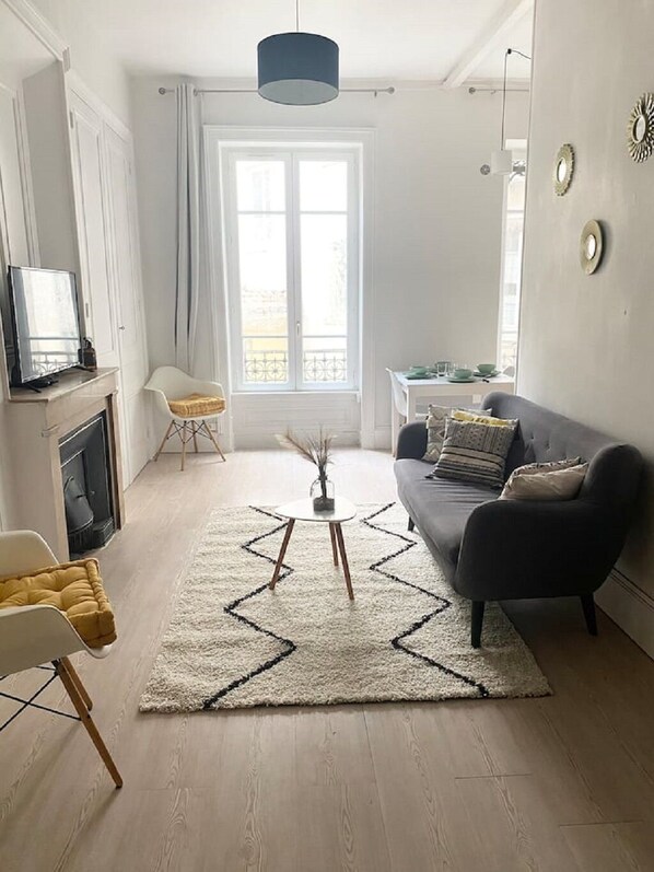 Un salon moderne avec un canapé, une table basse et un téléviseur.
