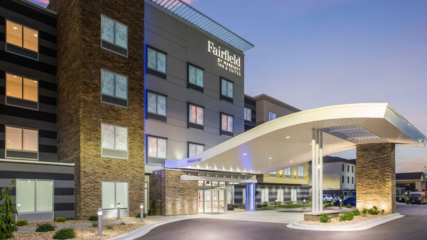 Ein Hotel Fairfield by Marriott mit modernem Design, das eine markante Eingangspartei und einen überdachten Außenbereich zeigt.
