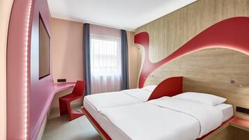 Een moderne hotelkamer met een groot bed, een bureau en een televisie.