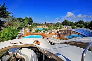 A water park with multiple slides, a swimming pool, and lounge areas with sunbeds. - Joli Mobil Home Dans Camping 4 Étoiles (Sarzeau)