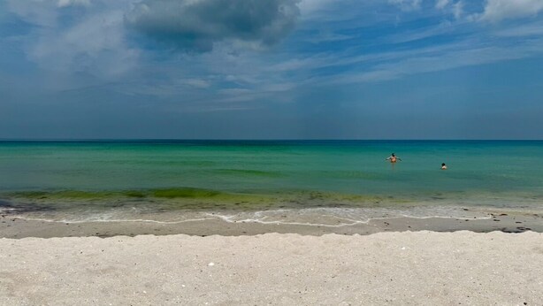 A beach with clear turquoise water, a sandy shore, and a partly cloudy sky. - Come and enjoy NAPLES Florida a slice of paradise (Naples)
