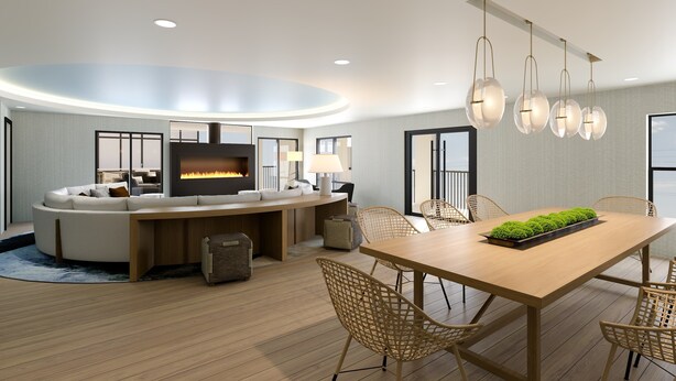 A modern living room with a curved sofa, a wooden dining table, wicker chairs, a flat-screen TV, and a fireplace.