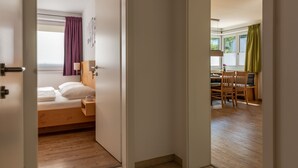 Una camera da letto con un letto di legno, un comodino e una finestra con tende.