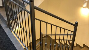 Una scala con ringhiera in metallo e un lampadario sulla parete.