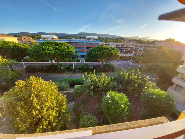 A residential area with a mix of modern and traditional buildings, a well-maintained garden, and a clear view of the surrounding landscape.