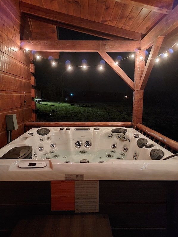 Un jacuzzi con panel de control y vista a un espacio verde por la noche.
