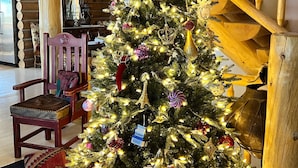 Un árbol de Navidad con luces y adornos en un interior de madera.