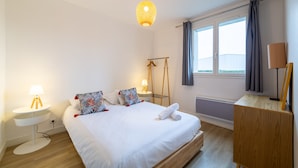 A neatly arranged hotel room with a bed, bedside tables, a lamp, a wardrobe, and a window with curtains. - HAPPY KOOL | city center | wifi | private parking (Blois)