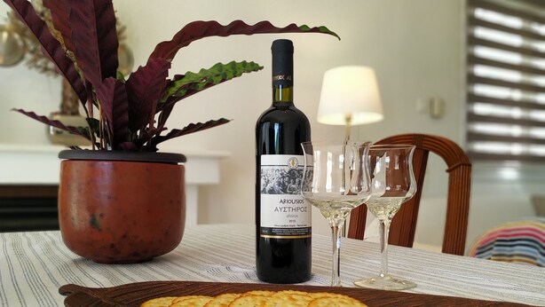 Ein Tisch mit einer Weinflasche, zwei Gläsern und einer Platte Cracker.