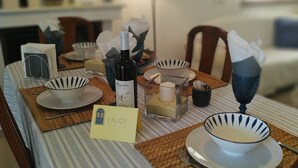 Una mesa puesta con platos, una botella y una vela.