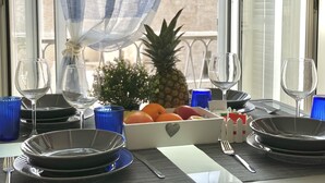 Una mesa servida para una comida, con platos, cubiertos y un frutero.