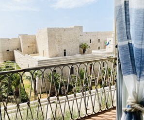 Enjoy breathtaking views of historic architecture from this balcony with a metal railing and lush green surroundings.