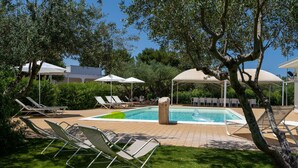 A pool area with lounge chairs, umbrellas, and a covered seating area. - Countryside Villa with private pool in Puglia (Monopoli)