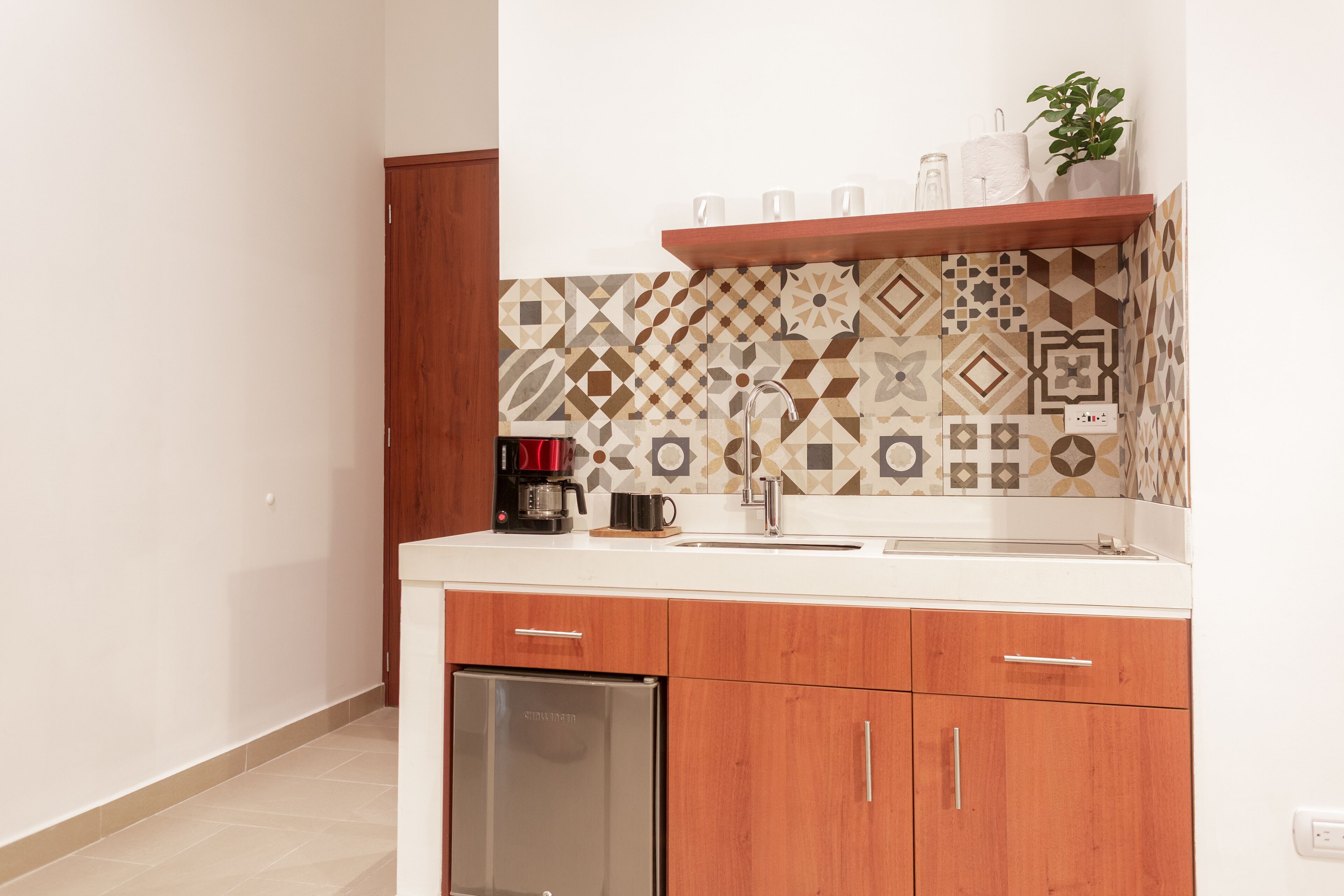 Une cuisine moderne avec un crédence décorée, des armoires en bois et un lave-vaisselle encastré.