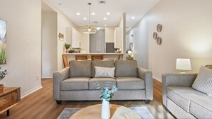 Ein Wohnzimmer mit einer Couch, einem Couchtisch mit einer Vase und einer Lampe.