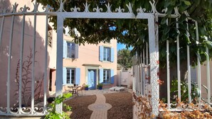 Une entrée fermée par un portail mène à un bâtiment, et un chemin pavé conduit à une porte.