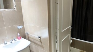Ein Badezimmer mit Waschbecken, Spiegel und Duschbereich.