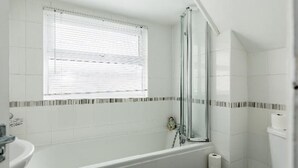 A bathroom with a bathtub, a toilet, and a shower area. - Luxury 3 bedroom apartment (Boscombe)
