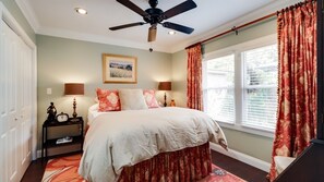 Relax in this serene bedroom with a large bed, bedside tables, and a ceiling fan.