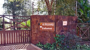 A rustic wooden gate with a sign reading "El Descanso Cabanas."