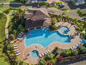 An aerial view of a resort with a large swimming pool, multiple lounge areas, and lush landscaping. - Condo in beautiful Poipu - 3Bd, 3Ba, pool, hot tub & AC (Koloa)