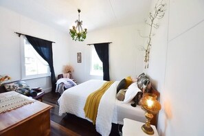 A bedroom with a bed, bedside table, and a chandelier. - Lux. Waterfront Cottage, Amazing Water Views /Fire Pit /Central/5km-MTB & Beach (George Town)