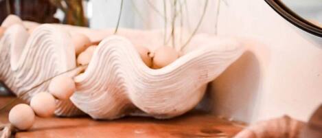 Una mesa de madera rústica con un cuenco de cerámica que contiene huevos y una nuez decorativa.