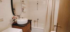 Bathtub, hair dryer, slippers, bidet