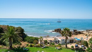 A coastal property with a beach, palm trees, and a clear view of the sea. - Oceanfront adorable one bedroom apart in Albufeira (Albufeira)