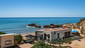 A beachside building with a patio area, a small pool, and a view of the ocean. - Oceanfront adorable one bedroom apart in Albufeira (Albufeira)