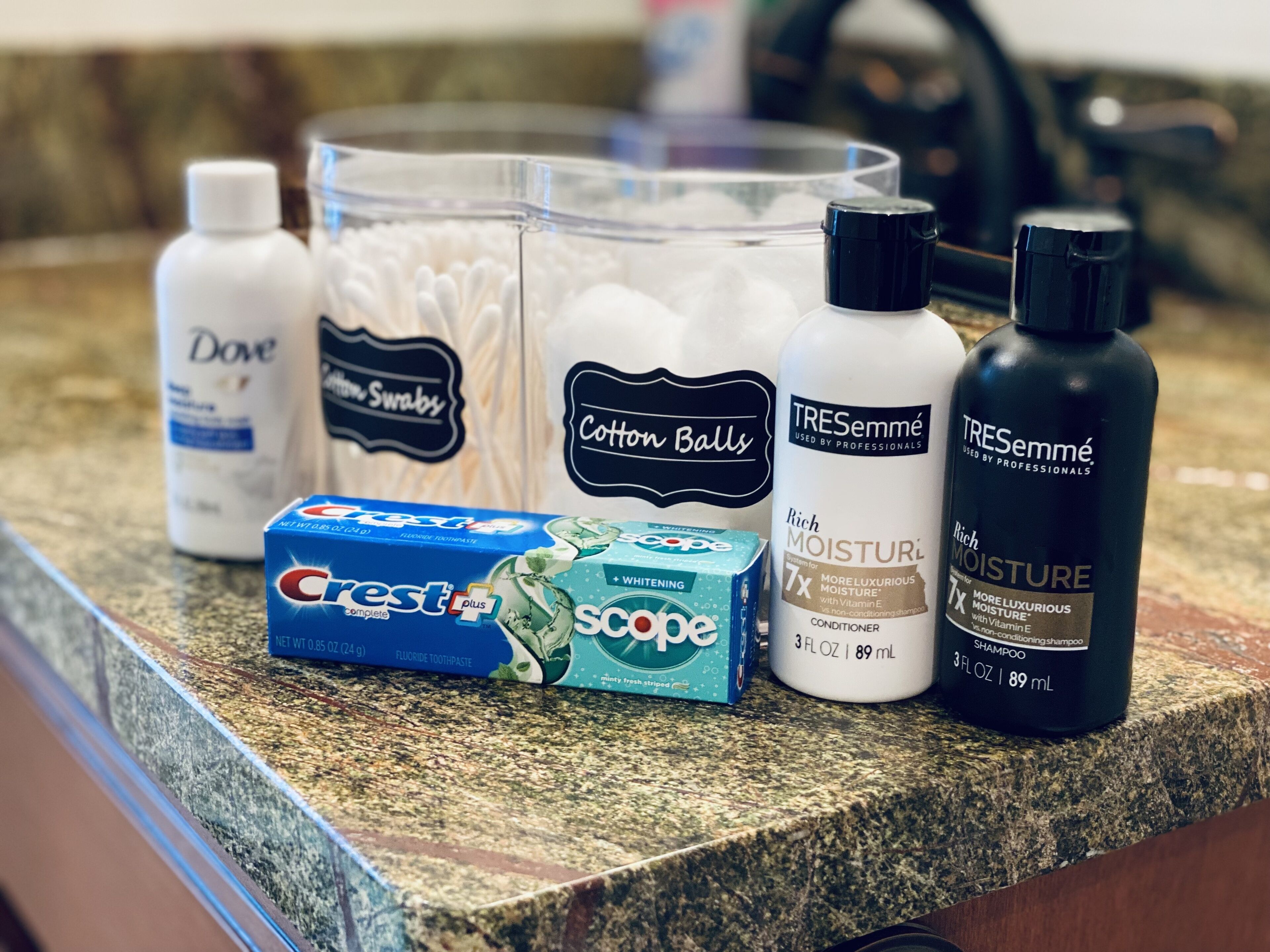 Un comptoir sur lequel on trouve divers produits de soins personnels, notamment du dentifrice Crest, des cotons et les shampooings et après-shampooings TRESemmé.